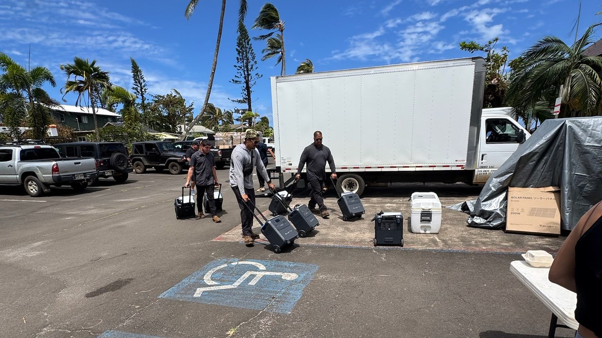 Crew wheeling BLUETTI portable power stations off a delivery truck on Kauaʻi